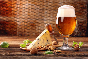 Blauschimmelkäse-Vorspeise und Bier auf braunem Vintage-Hintergrund