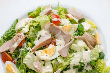 Nutritious vegetable salad with boiled egg slices and salmon