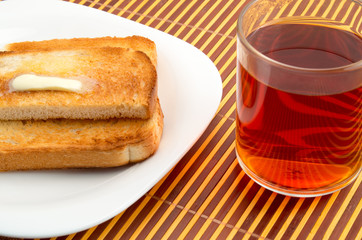 Transparent cup with tea and toast