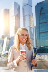Fototapeta premium Young attractive business woman holding folder and cup of coffee