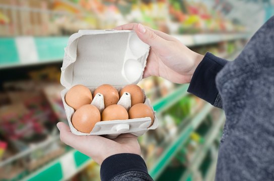Man holding egg box in supermarket
