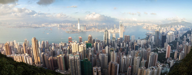 Wide panorama of Hong Kong's skyline viewed from the Victoria Peak in daylight.