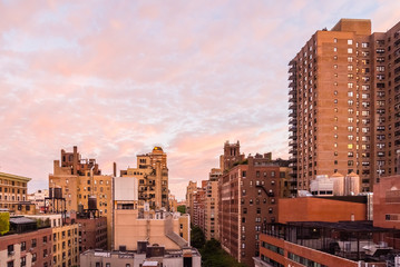 Balcony view of a New York City neighborhood with a colorful morning sky.