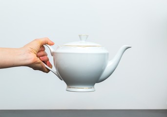 Elegant porcelain white jug and woman hand