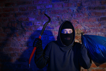 Night gangster near brick wall