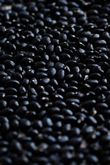 Dried black beans background. Dark textured wallpaper