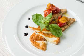 Delicious toast sandwiches with fried cheese, tomatoes, olive oil and basil