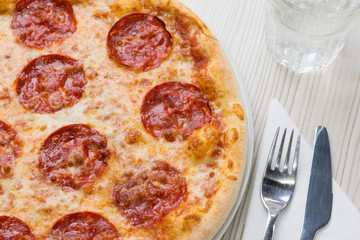 Detail of delicious salami pizza on the table