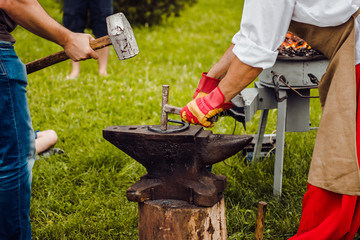 A smith forging a horse shoe on an anvil