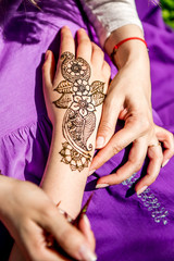Obraz na płótnie Canvas Picture of human hand being decorated with henna tattoo, mehendi
