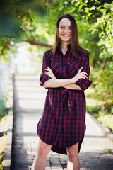 Fototapeta premium cute girl in a checkered dress at summer park