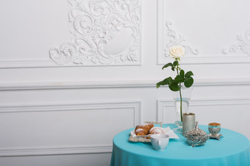 croissant and white rose on a table against luxury wall, copy space