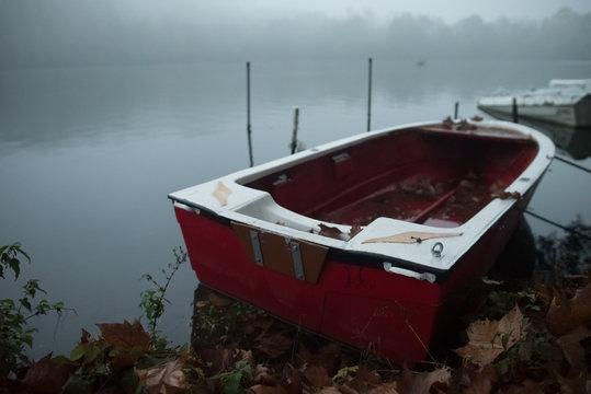 Small boat on the bank of a river in the fog