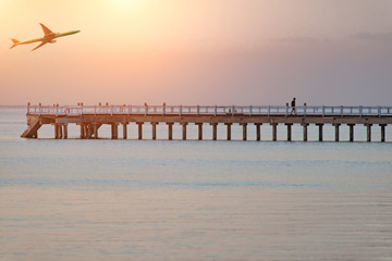 Fototapeta na wymiar empty footbridge, long boardwalk on the lake in the evening at sunset
