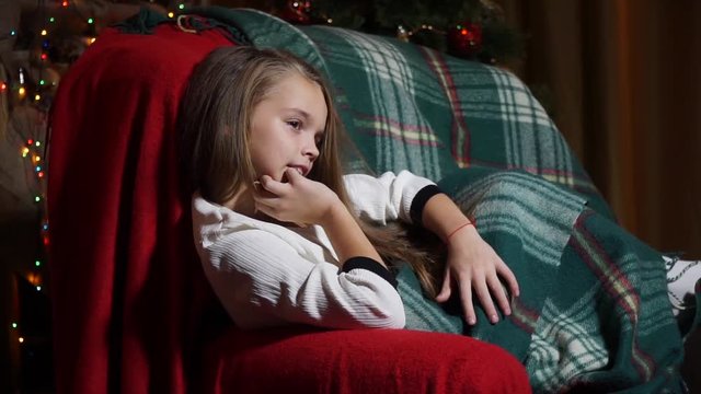 Sweet girl in plaid evening sitting in a chair