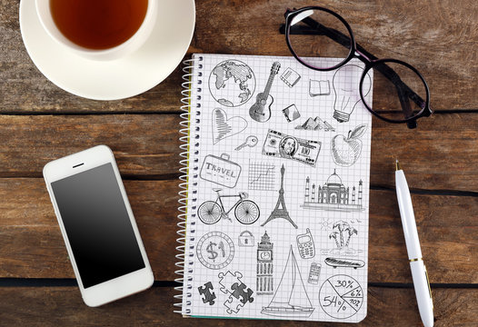 Notebook with drawings and smartphone on wooden table. Creative concept.