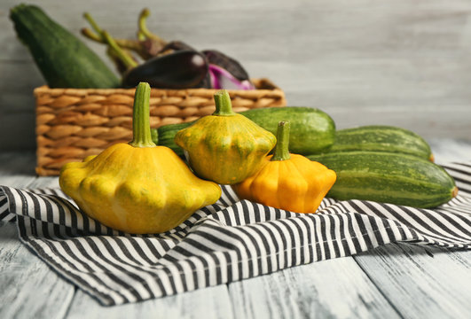 Composition with fresh squashes and napkin on blurred gray background