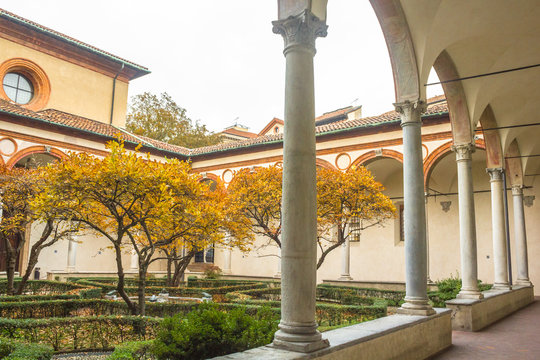 courtyard of church Santa Maria Delle Grazie, access to it's refectory hosting The Last Supper painting by Leonardo da Vinci with trees in autumn colors.
