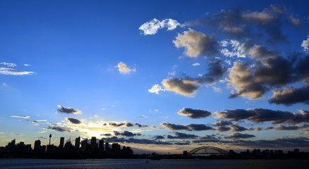 The sunset slowly goes down at Bradley's Head, Sydney, Australia. Sydney Harbour ocean water wide panoramic view on the CBD city at Sunset.