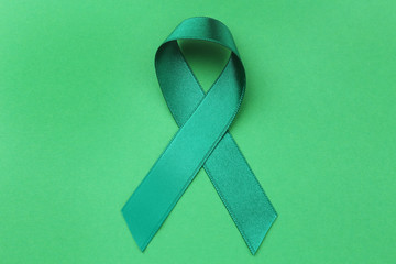 Green ribbon on color background. Mitochondrial diseases and kidney cancer concept