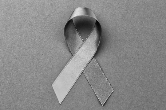 Grey ribbon on color background. Brain cancer, diabetes, asthma concept