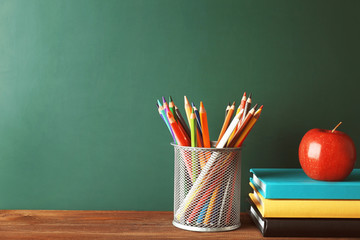 Colorful school stationery on table on blackboard background © Africa Studio