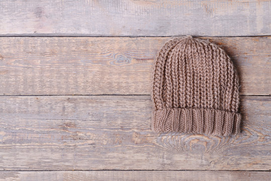 Beige Knitted Cap On Wooden Background