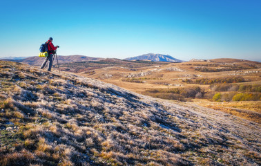 Obraz premium Photographer takes pictures on top of the mountain in autumn. 