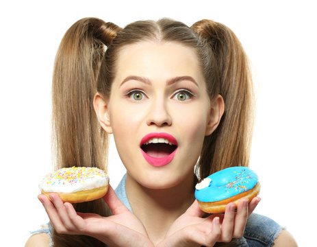 Funny young woman with tasty donuts on white background, close up