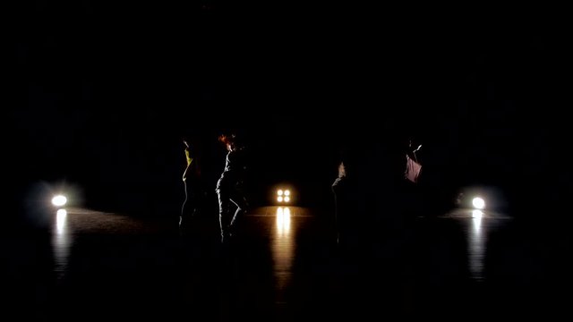 Silhouettes of dancers posing with classical and modern hip hop dance. Dance on basketball arena