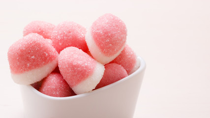 Pink jellies or marshmallows with sugar in bowl