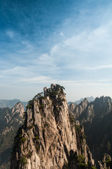Fototapeta na wymiar Huangshan Mountain Range - Anhui Province - China. Scenic landscape with steep cliffs and trees during a sunny day