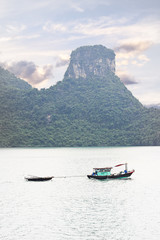 Boat sailing on Halong Bay, UNESCO world heritage site. Limestone islands protrude from the water.
