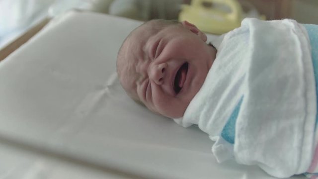 Newborn Baby Crying in Hospital Delivery Room Bed