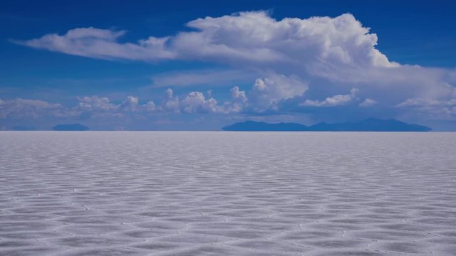 白雲とウユニ塩湖の大地