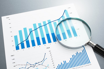 Reviewing business report. Looking at growth chart with magnifying glass.
Document, charts and...
