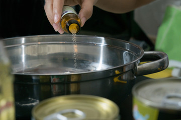 pouring some yeast in to the stainleass blow mixing with flour preparation step to cooking some food that by flour