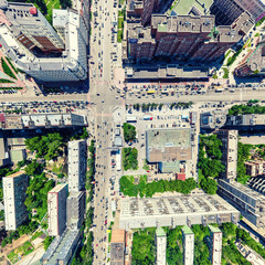 Obraz premium Aerial city view with crossroads and roads, houses, buildings, parks and parking lots, bridges. Urban landscape. Copter shot. Panoramic image.