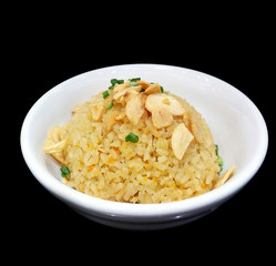 Thai garlic fried rice with vegetable on top in white bowl isolated on black background