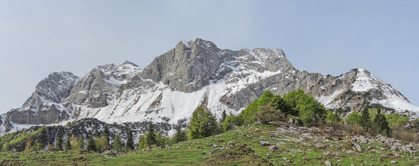 Obraz premium Landscape at Orobie Alps during spring season. Snow is melting. Valcanale area. Path from Alpe Corte lodge to Branchino natural lake. Arera Group of mountain