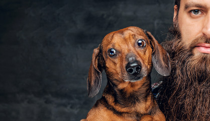  Portrait of brown badger dog and his bearded man friend.