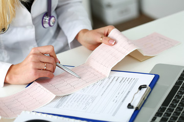 Doctor hands with cardiogram chart on clipboard pad