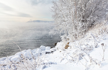 Lake Baikal in the November cold day. Trees on the shore covered with beautiful white frost