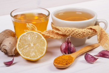 Cup of tea with lemon and ingredients for preparation warming beverage