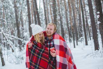 young couple sheltered red plaid holding a hot tea