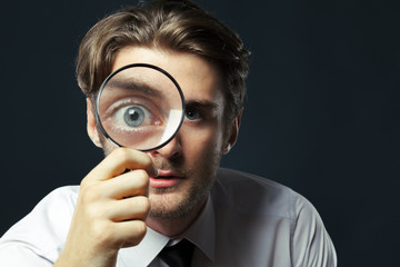 Fototapeta na wymiar business man holding magnifying glass