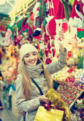 Obraz na płótnie Canvas Happy glad girl choosing Christmas decoration at market