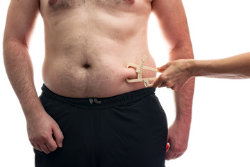 Doctor is pinching an overweight man with calipers to measure the fat level