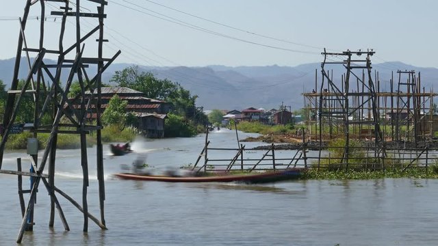 Long boats float between stilted houses in village on famous Inle Lake, timelapse, 4k
