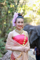 Woman wears thai dress with her elephant
